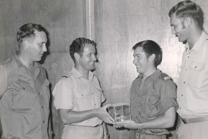 Commanding Officer and the Provost Marshall presenting Darryl with the remains of the grenade that had injured him