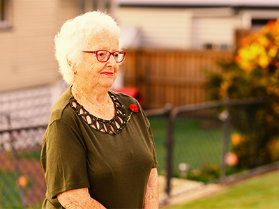 Older woman commemorating on driveway ANZAC Day