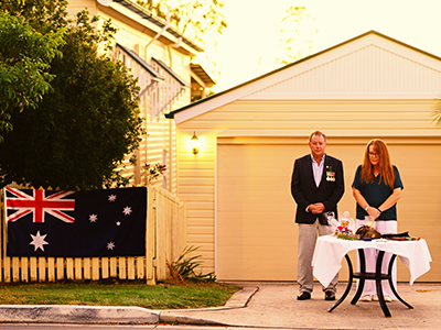 Veteran and wife commemorating on ANZAC Day on driveway