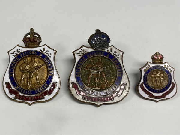 Original Stokes and Sons RSSILA badges compared with a later and smaller version of the Insignia. The badge in the centre has a financial clip for 1921 attached to its crown (RSL Queensland Collection)