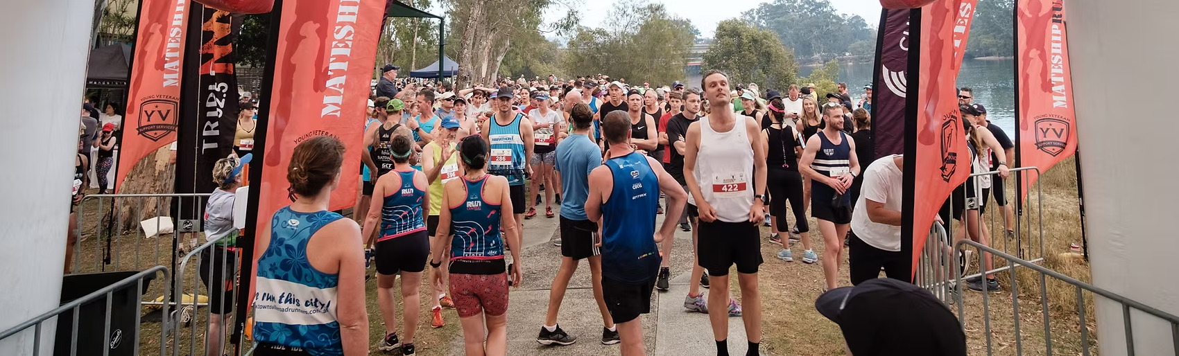 MATESHIP RUN banner. People standing at the start line of the Mateship Run event. 