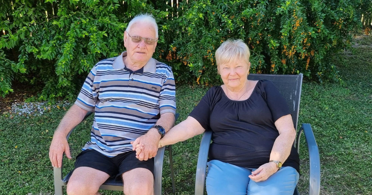 Sandra and David sit on chairs on the lawn