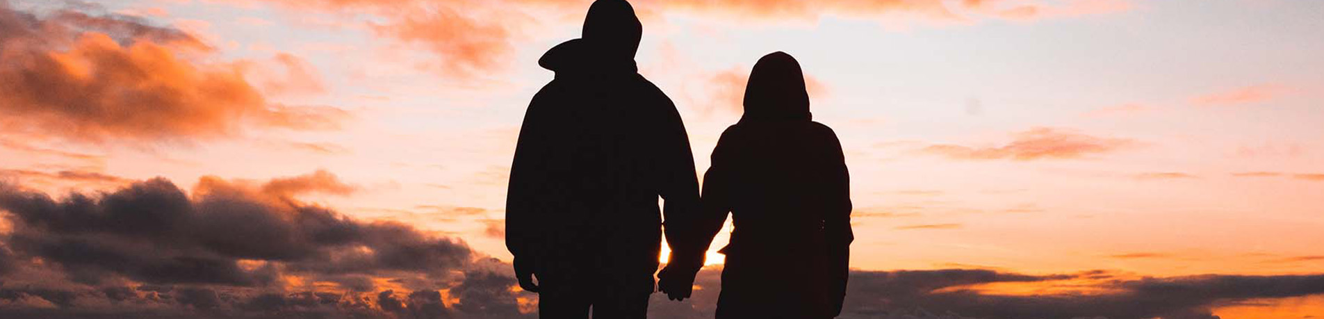 ADF couple holding hands watching the sunset